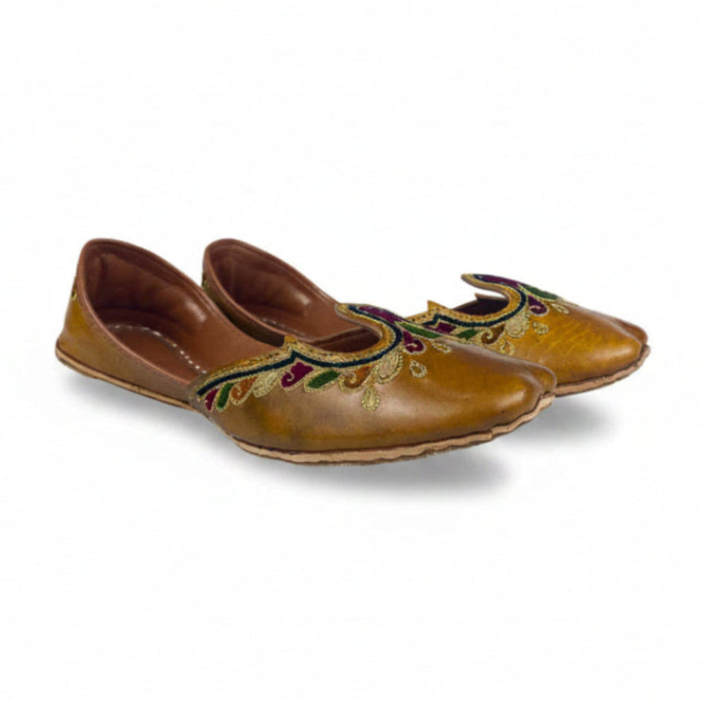 Pair of brown shoes with decorative patterns on a white background
