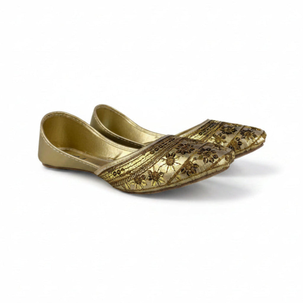 Pair of gold embroidered shoes on a white background