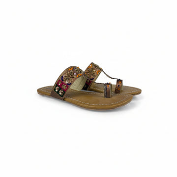Brown sandal with decorative straps on a white background