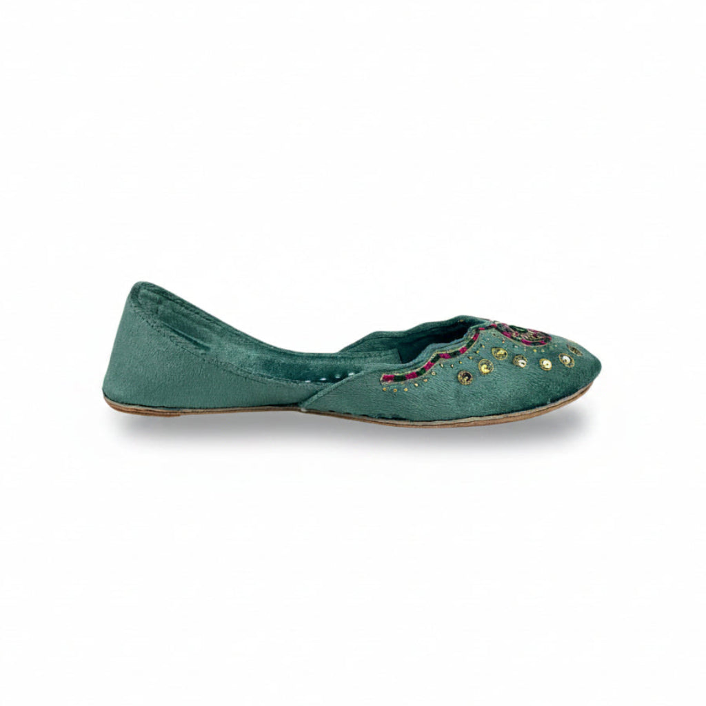 Pair of turquoise embroidered slippers on a white background