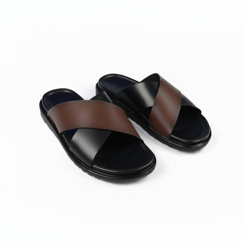 A pair of black leather slide sandals with crisscrossing straps and thick black soles, photographed on a clean white background.