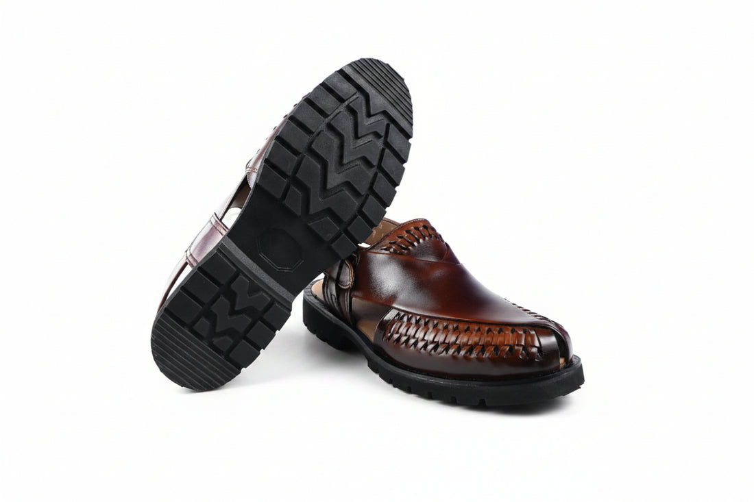 A pair of black  slingback moccasin-style shoes with braided detailing on the toe and a small gold buckle, shown on a plain white background.