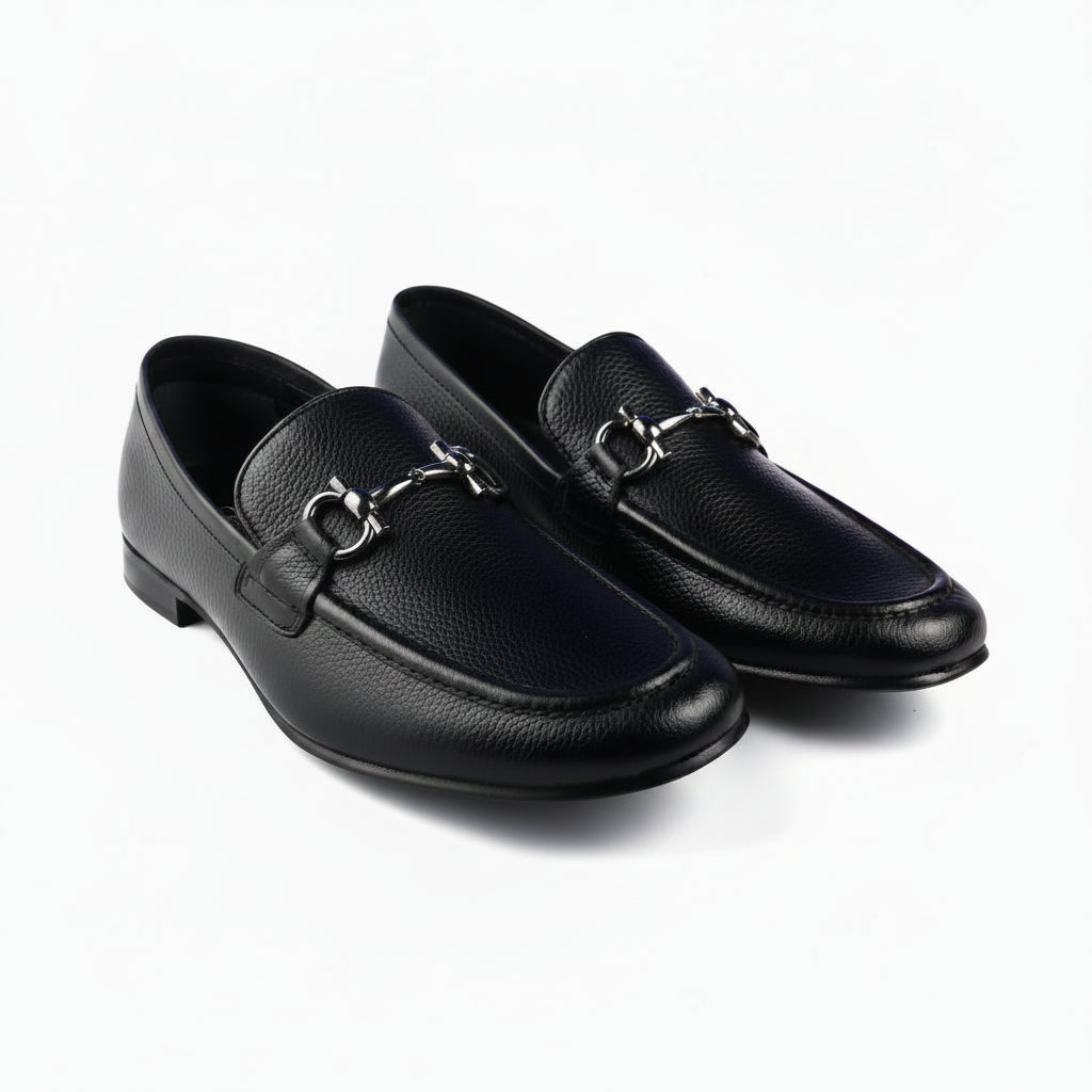 A pair of black pebbled loafers with a silver-tone horsebit detail across the vamp, displayed on a clean white background.