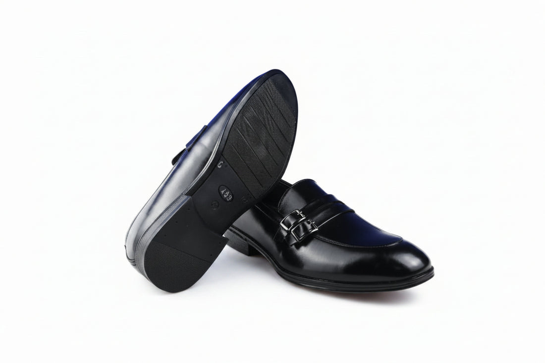 A pair of dark brown penny loafers with silver-tone buckle details, displayed on a clean white background.