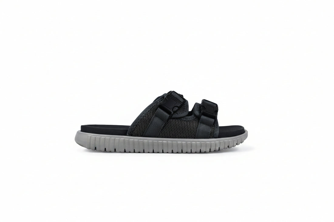 A pair of navy blue double-strap slide sandals with white soles, photographed on a white studio background.