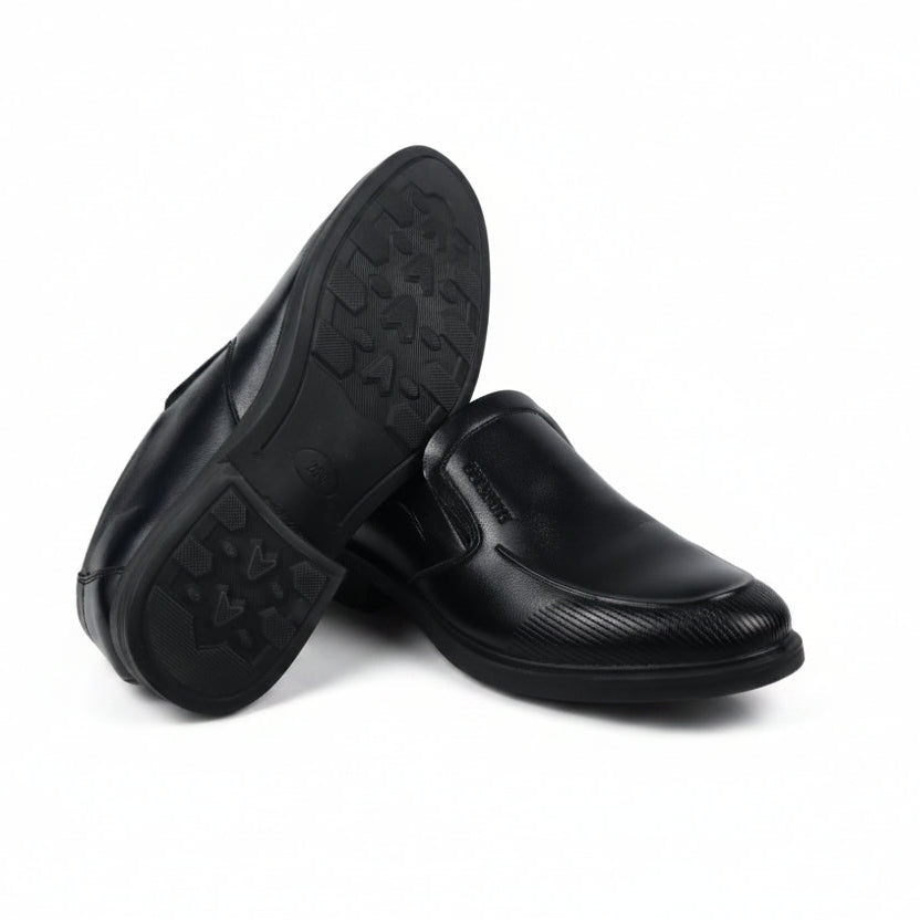 A pair of black slip-on loafers, with one shoe turned to show the textured outsole, set against a plain white background.