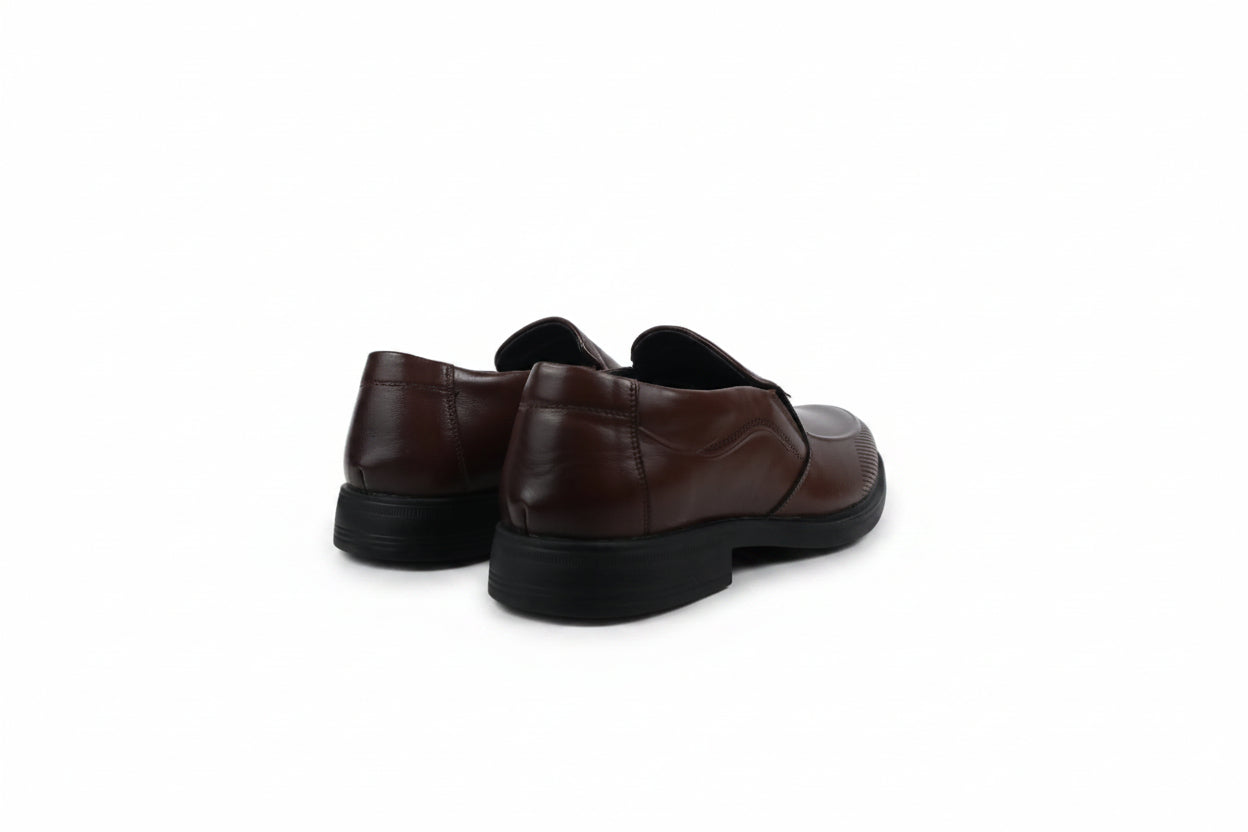 A pair of dark brown  slip-on loafers with black soles, shown from a rear three-quarter angle on a plain white background.