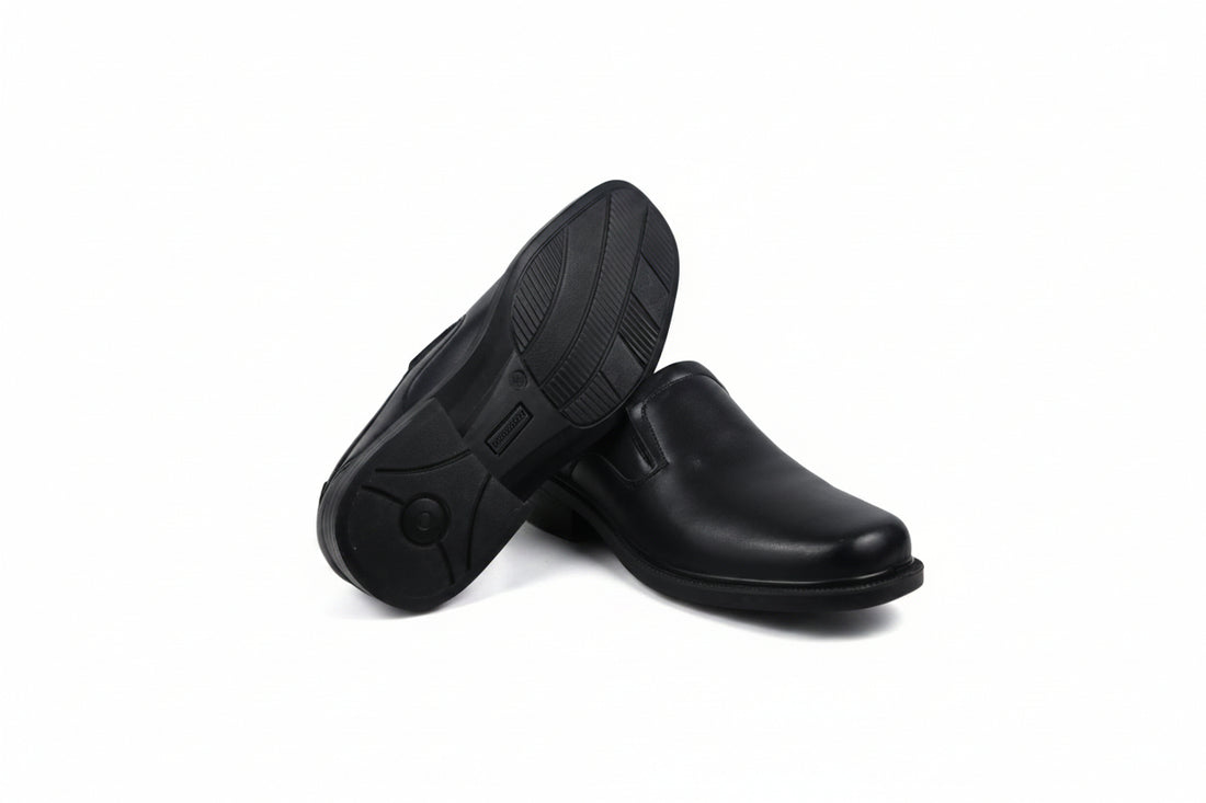 A pair of black slip-on dress shoes with low block heels, displayed on a clean white background.