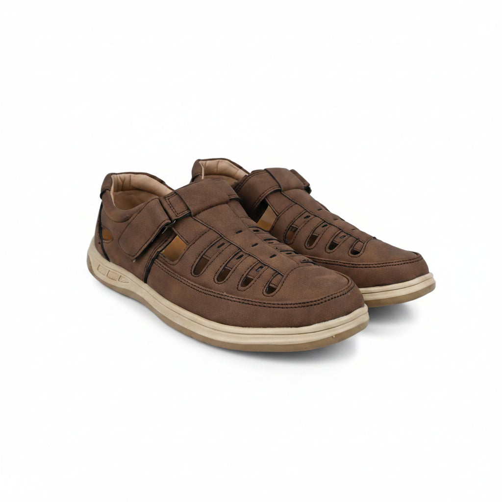 A pair of brown  slip-on shoes with decorative laces and beige soles, photographed on a light gray fabric background.