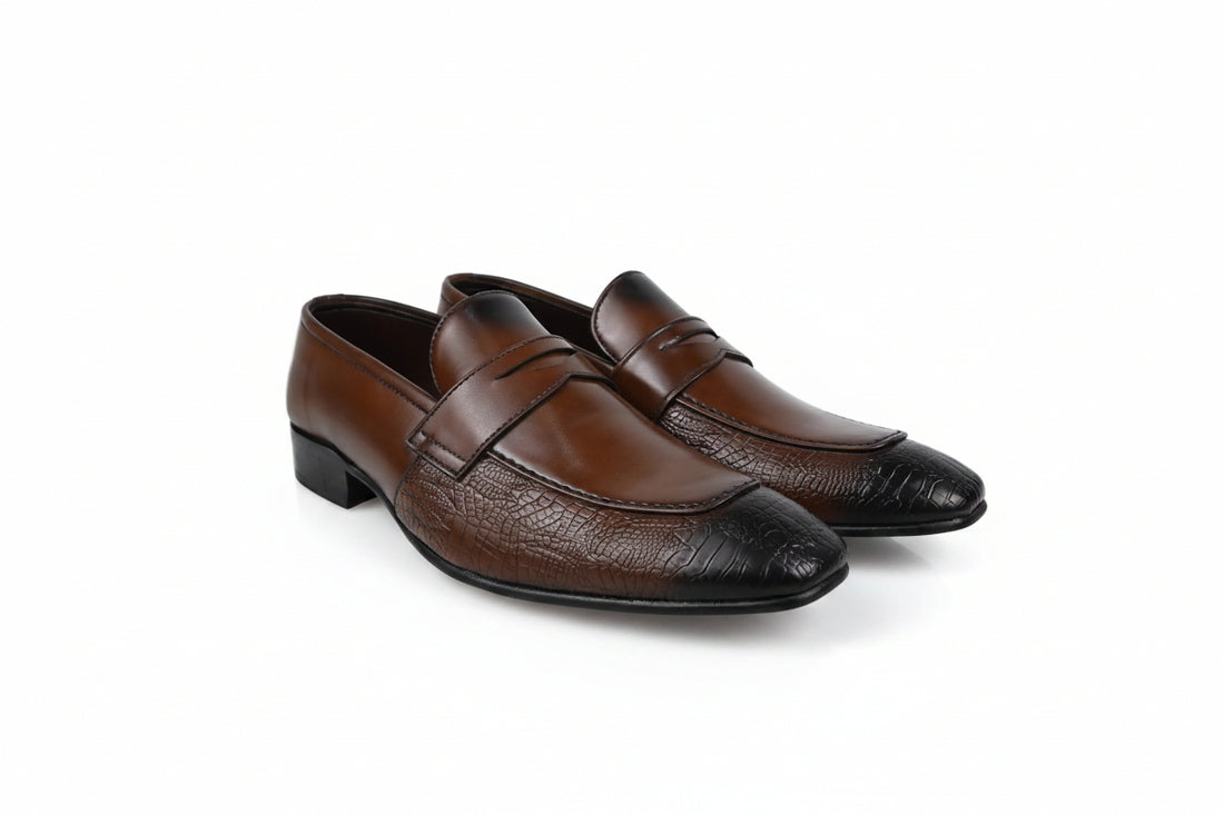 A pair of men's brown  penny loafers with a textured crocodile pattern on the toe caps, displayed on a white studio background.