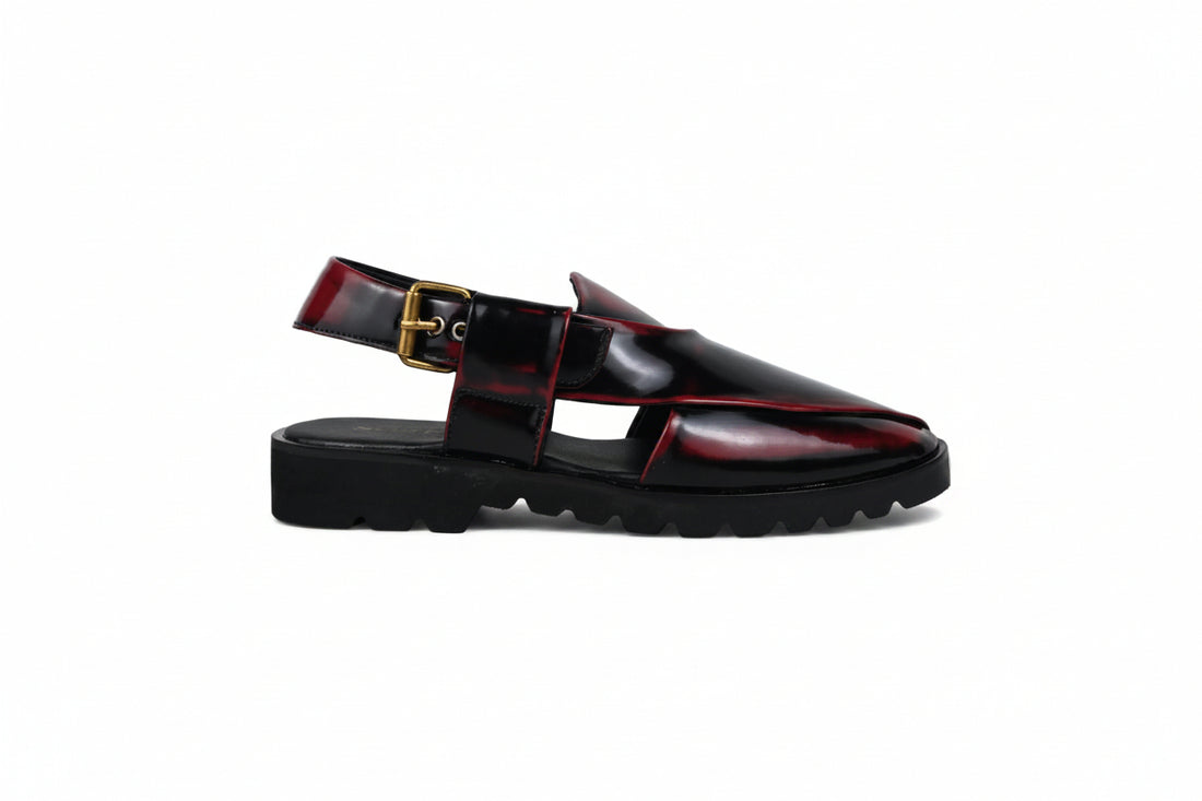 A pair of glossy black  clog-style loafers with deep red inlay panels and a small gold buckle detail, shown on a light gray background.