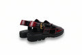 A pair of black platform mule sandals with glossy red side panels and a gold buckle detail, photographed on a white studio background.