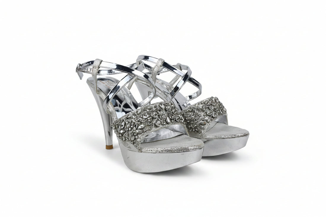 A pair of gold platform high-heeled sandals with metallic straps and a glittery embellished toe area, shown against a plain light background.