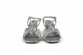 A pair of women's strappy high-heeled sandals with silver metallic straps and rhinestone embellishments, shown against a plain light gray background.