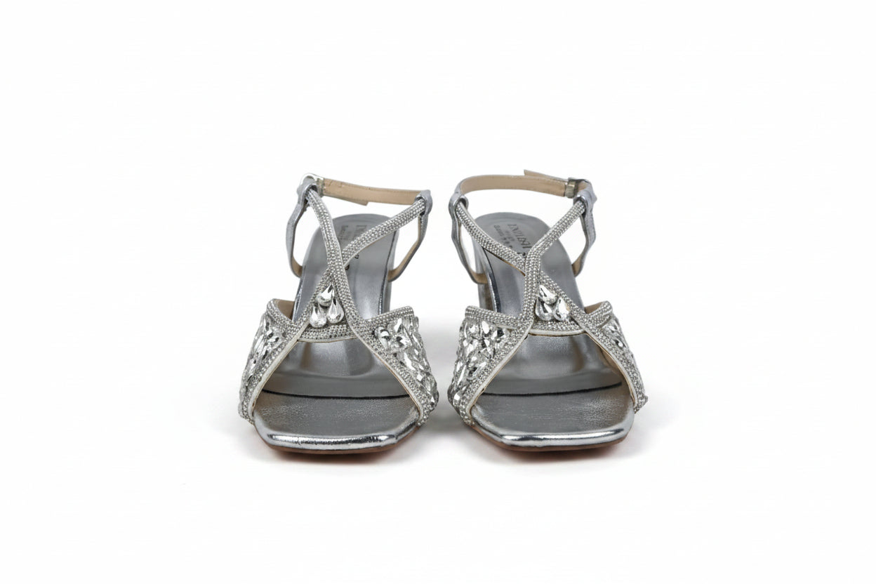 A pair of women's strappy high-heeled sandals with silver metallic straps and rhinestone embellishments, shown against a plain light gray background.