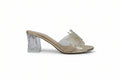 A single women's heeled mule sandal with a clear transparent block heel, a metallic gold footbed and trim, and a clear strap embellished with rhinestones, shown against a white studio background.