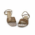 A pair of women's heeled sandals with metallic gold woven straps and square toes, shown on a light gray background.