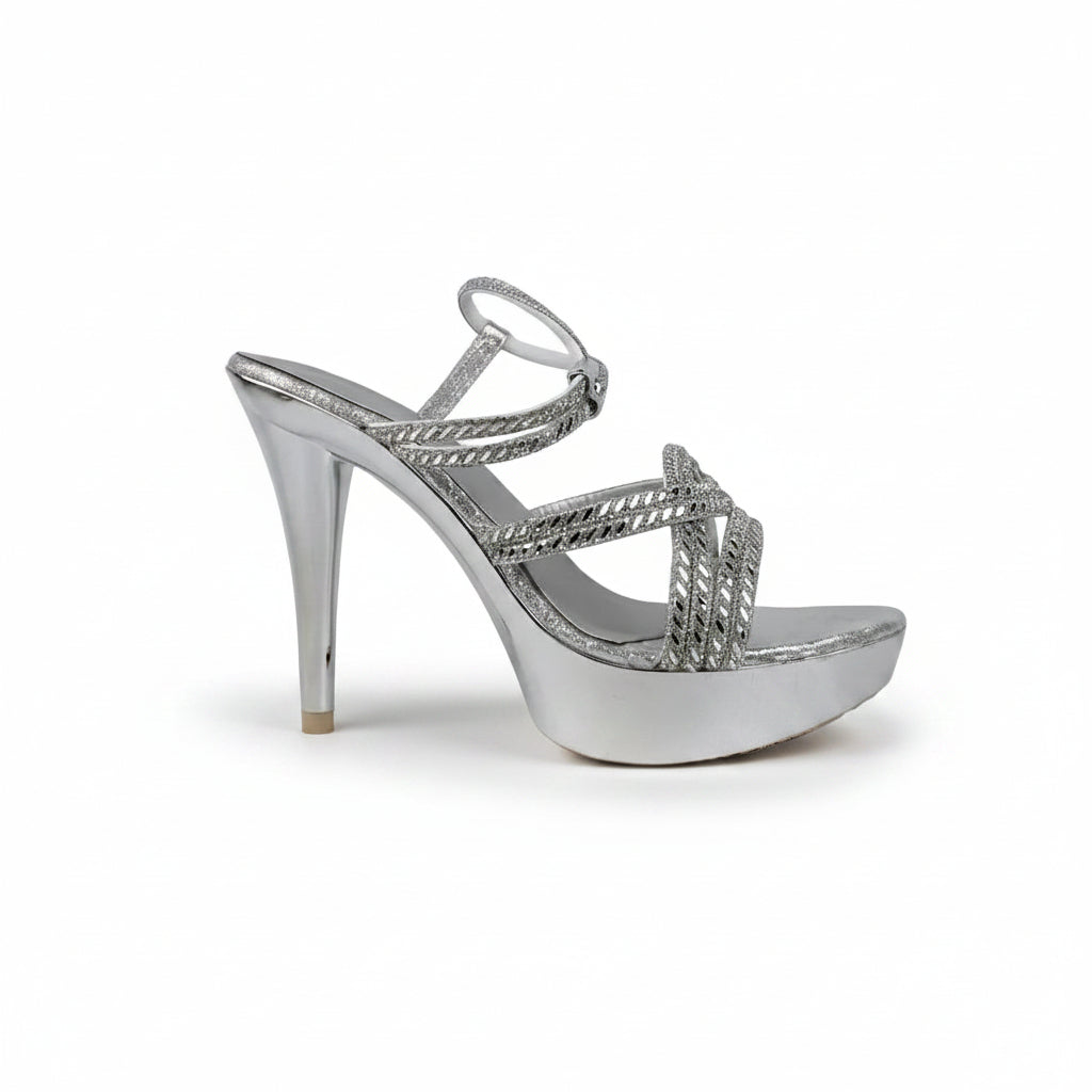 A single metallic silver high-heeled sandal with a platform sole and braided strap details, photographed against a light gray fabric backdrop.