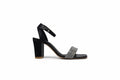 A single black high-heeled sandal with an ankle strap and a sparkling rhinestone-embellished toe strap, shown from the side against a light gray background.