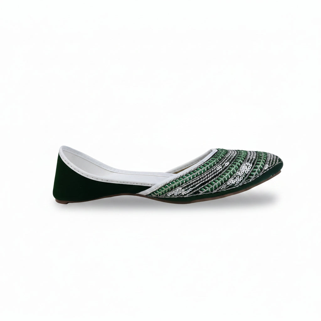 A single flat shoe with a dark green velvet heel and toe cap, and a white and green patterned fabric body, shown against a white studio background.