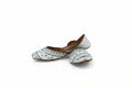 A pair of traditional white leather mule slippers with blue and black embroidered patterns, displayed against a plain light gray background.