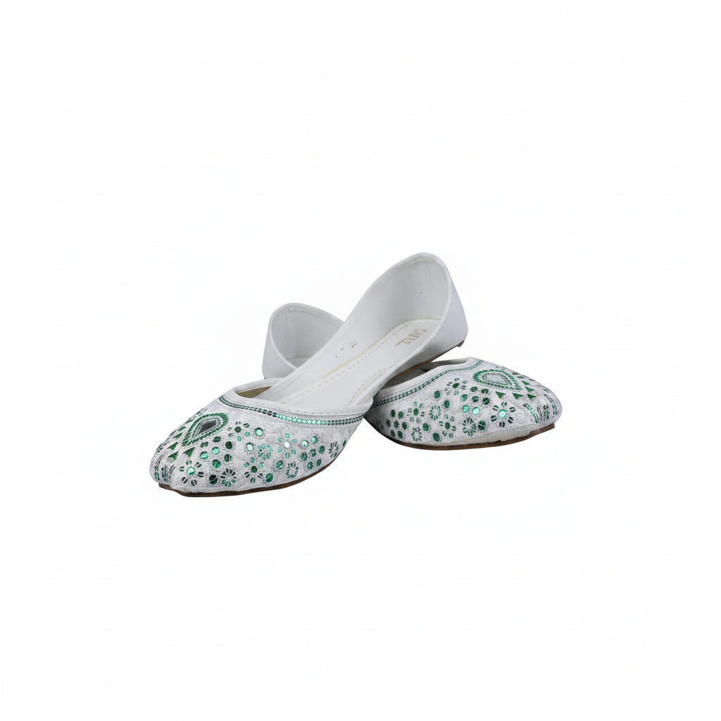 A pair of white flat slip-on shoes decorated with green sequins and beadwork, displayed on a light gray surface.