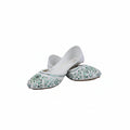 A pair of white traditional flat shoes with green and blue floral embroidery on the toe caps, displayed on a light gray fabric background.