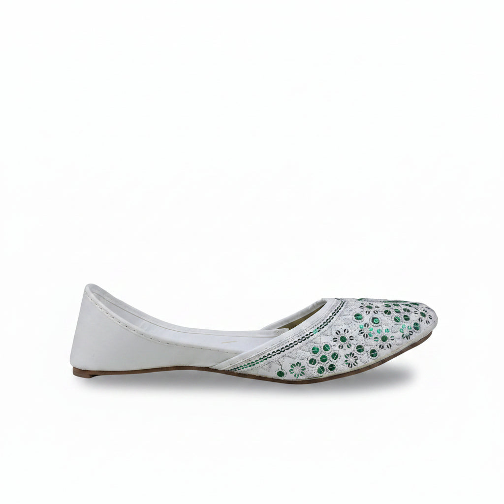 A single white flat shoe with green and blue floral embellishments on the toe, shown against a light gray background.