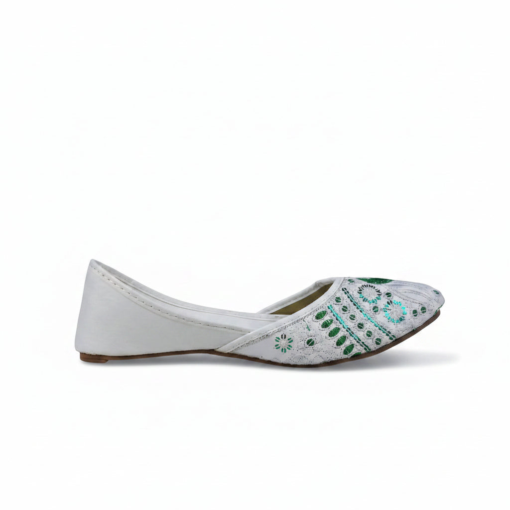 A single white flat shoe with intricate green and blue embroidered patterns on the toe, shown from a side profile against a light gray background.