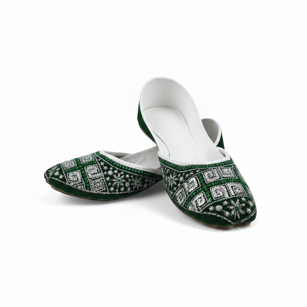 A pair of traditional green and white embroidered flat shoes, likely Jhugga or Kameez, displayed on a light gray background.