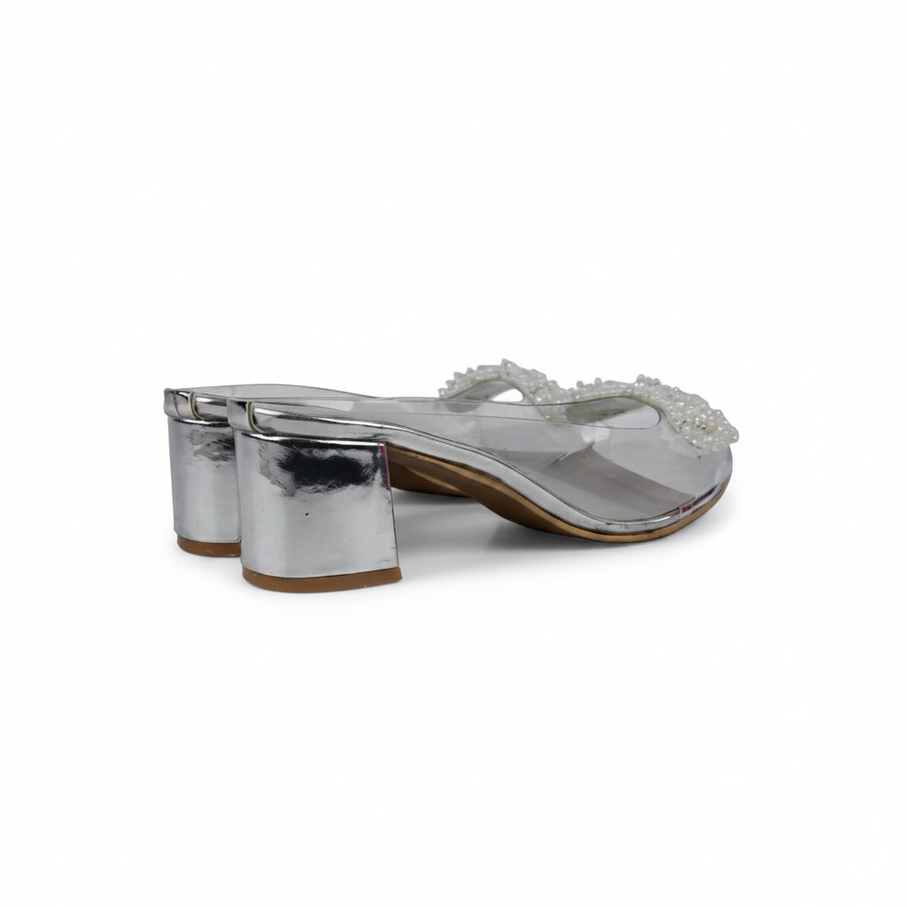 A pair of women's silver metallic block-heel thong sandals with a clear strap embellished with white beads, shown on a white surface.