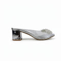 A single silver metallic mule sandal with a chunky block heel and a clear embellished toe strap, shown from a side profile on a light gray surface.