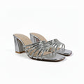 A pair of women's metallic silver heeled sandals with woven strap details and square toes, shown on a white studio background.