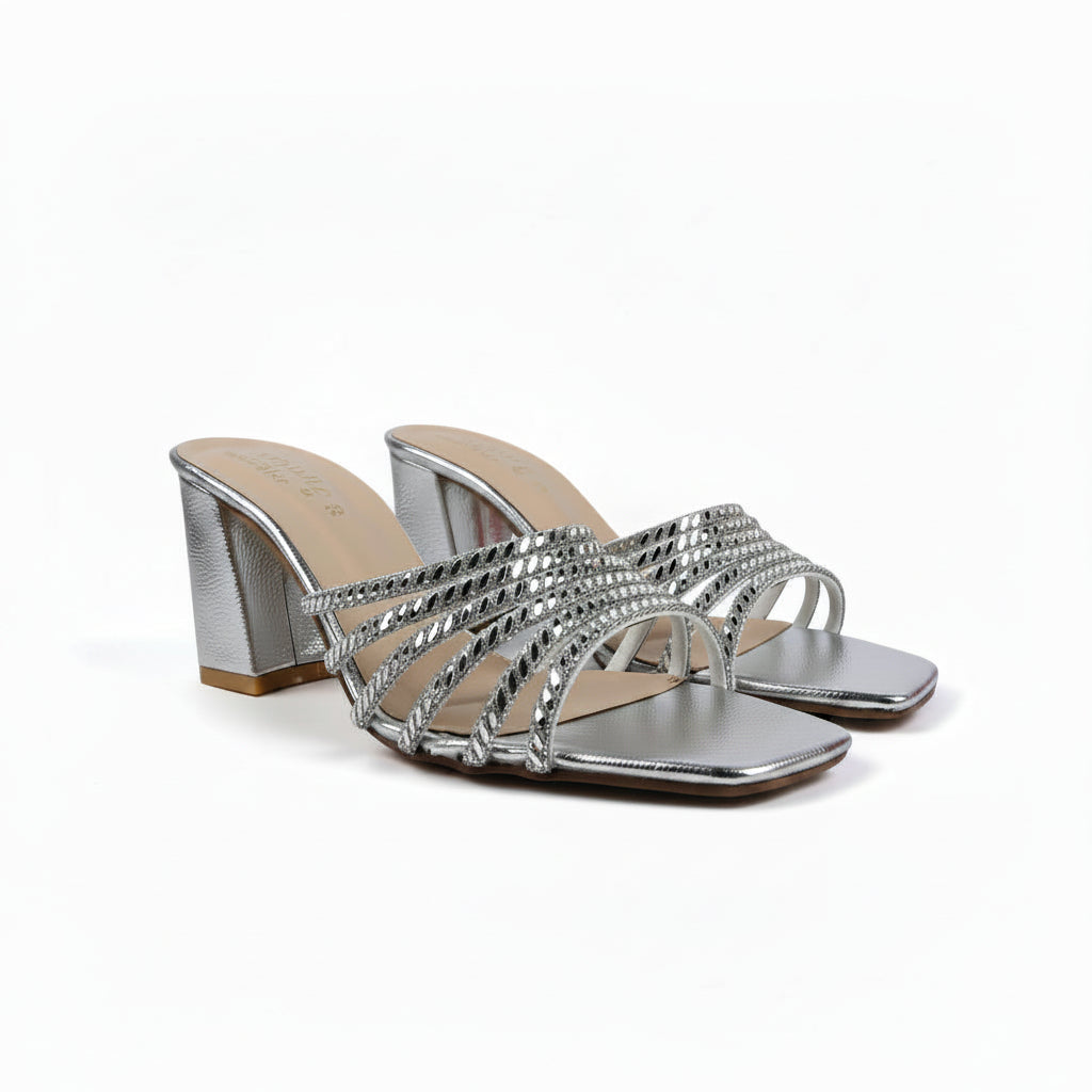 A pair of women's metallic silver heeled sandals with woven strap details and square toes, shown on a white studio background.