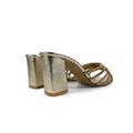 A pair of metallic gold block-heel mule sandals with woven metallic straps, shown from a side angle on a white surface.