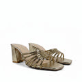 A pair of metallic gold block-heel slide sandals with multiple twisted rope-style straps, shown on a light gray fabric background.