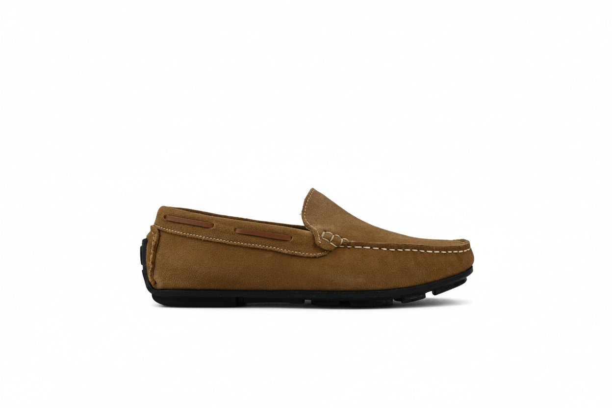 A tan suede moccasin loafer with white contrast stitching and a black rubber sole, shown in profile against a white studio backdrop.