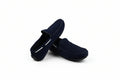 A pair of dark navy blue suede moccasin-style slip-on shoes photographed on a white studio background.