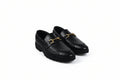 A pair of black leather loafers with a woven pattern on the sides and a gold-tone horsebit detail on the toe, displayed on a white studio background.