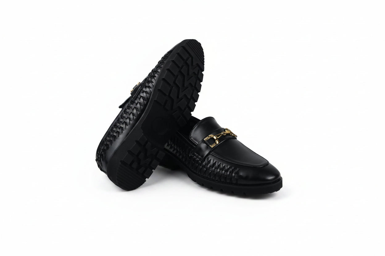 A pair of black leather loafers with a textured woven pattern on the sides and a gold-tone horsebit detail on the toe, displayed on a white studio background.