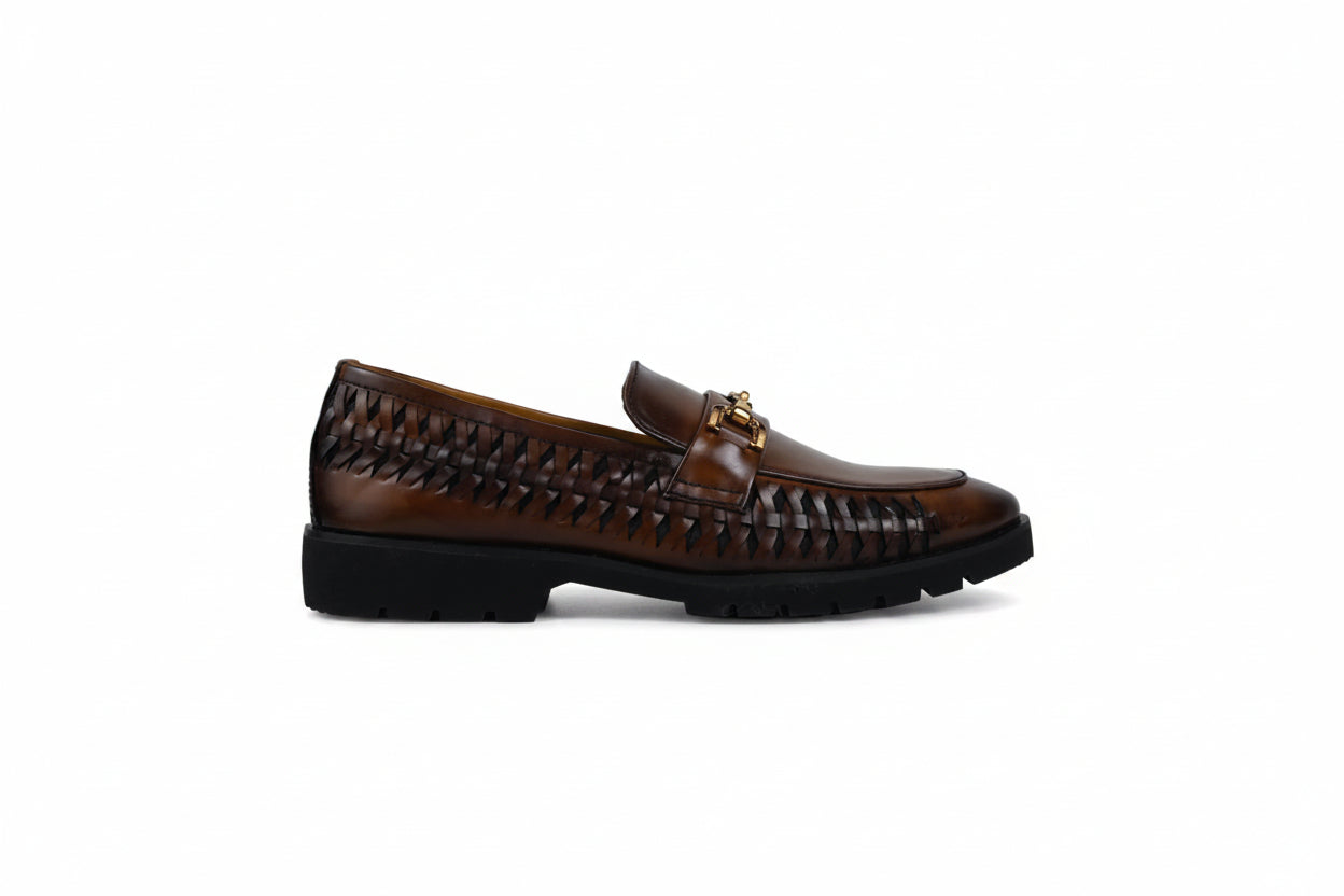 A single brown leather loafer with a braided woven pattern across the upper and a small gold-tone horsebit detail on the vamp, shown from a side profile against a light gray background.