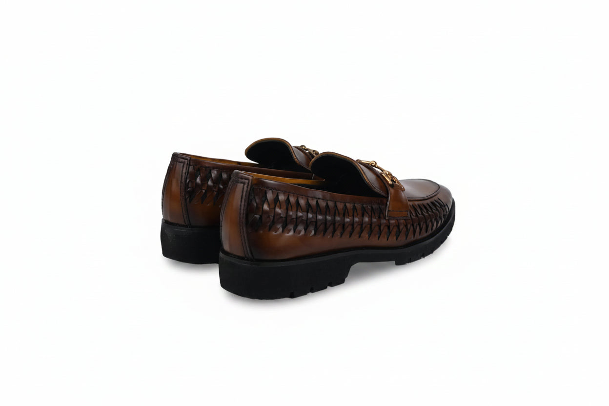 A pair of men's brown leather loafers with a woven pattern on the sides and a gold-tone buckle detail on the vamp, shown from a three-quarters angle against a white studio background.
