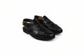A pair of black leather slingback clogs with a woven pattern on the upper, photographed on a white studio background.