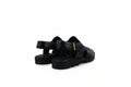 A pair of black leather platform sandals with cutout straps and a small gold buckle detail, photographed on a light gray studio background.
