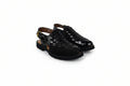 A pair of black woven leather slingback sandals with low block heels and gold-tone buckle details, displayed on a white studio background.