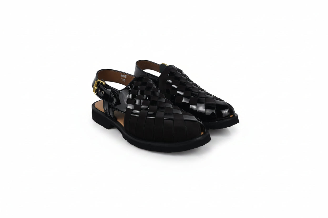 A pair of black woven leather slingback sandals with low block heels and gold-tone buckle details, displayed on a white studio background.