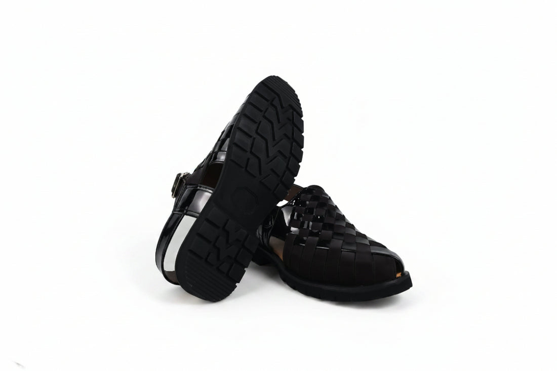 A pair of black woven leather slingback sandals with low block heels and gold-tone buckle details, displayed on a white studio background.