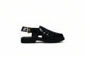 A single black woven leather sandal with a low block heel and a gold buckle on the ankle strap, shown from a side profile against a light gray background.