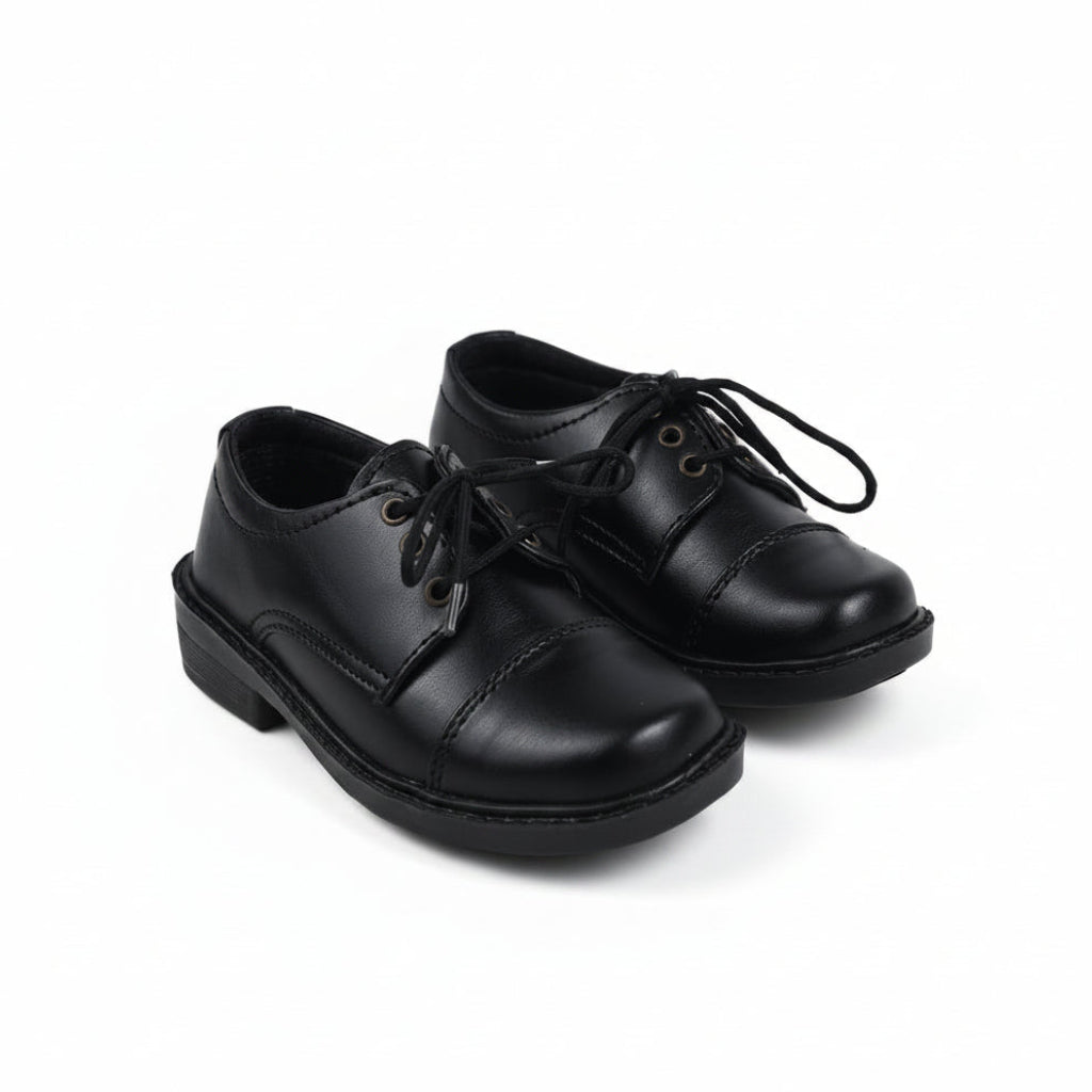 A pair of black leather lace-up shoes with low block heels, photographed on a light gray studio background.