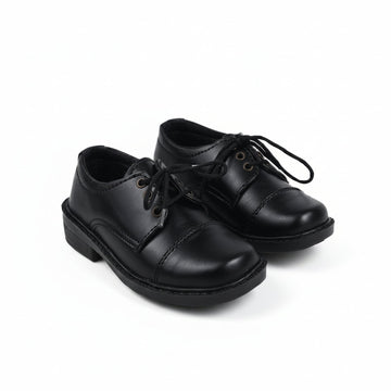 A pair of black leather lace-up shoes with low block heels, photographed on a light gray studio background.